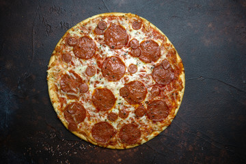 Italian pizza pepperoni on dark stone background
