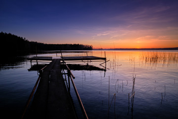 jetty leads out into the water with a beautiful sunset in the background
