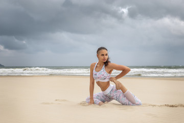 Fototapeta na wymiar Young beautiful woman practice yoga on sea sand