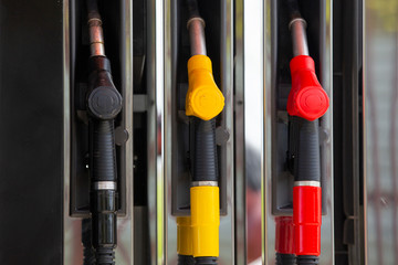 Close-up fuel nozzles on petrol and diesel fuel. Gas station pump. Man refueling gasoline with fuel in a car, holding a nozzle. Limited depth of field.