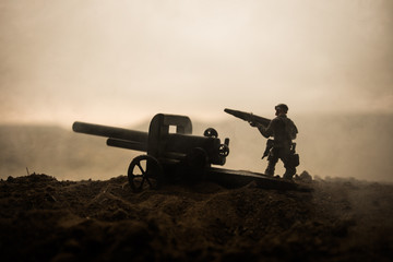 Battle scene. Silhouette of old field gun standing at field ready to fire. With colorful dark foggy background. Selective focus