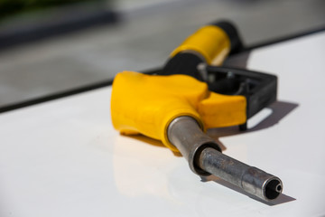 Gasoline pistol pump fuel nozzle Gas station pump. Man refueling gasoline with fuel in a car, holding a nozzle. Limited depth of field.