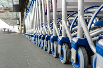 Trolleys luggage in a row in modern airport. Close up of luggage carts