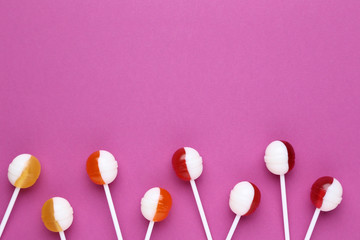 Sweet lollipops on crimson background