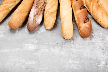 Fresh baguettes on grey wooden table