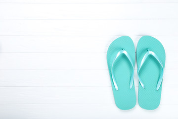 Pair of flip flops on white wooden background