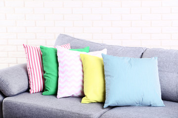 Colorful soft pillows on grey sofa