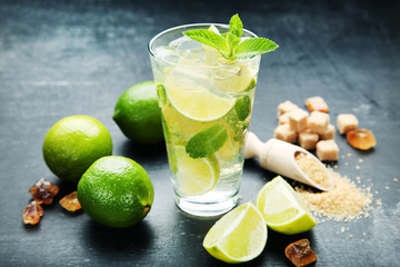 Mojito cocktail in glass with sugar on wooden table