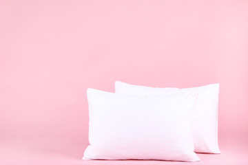 Soft white pillows on pink background