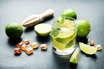 Mojito cocktail in glass with sugar on wooden table