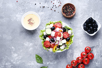 Vegetable salad in bowl with sauce and spices on grey background