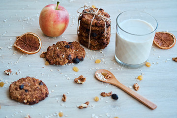 Homemade oatmeal cookies with walnut, raisins and milk on a wooden table