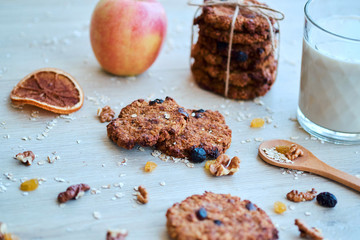 Homemade oatmeal cookies with walnut, raisins and milk on a wooden table