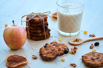 Homemade oatmeal cookies with walnut, raisins and milk on a wooden table
