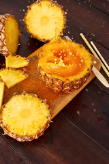 Splash fresh fruit juice with exotic pineapple on a wooden brown table. A composition made of ananas. Top wiev. 