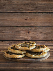 Arabic meat sfiha over a wooden table.