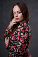 Portrait of a female in a colored dress on gray background