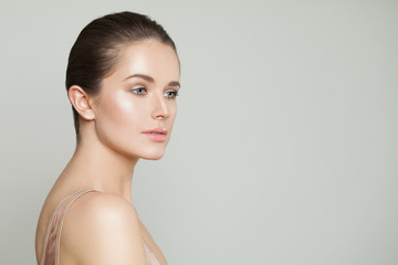 Young perfect female face. Healthy model with clear skin on gray banner background
