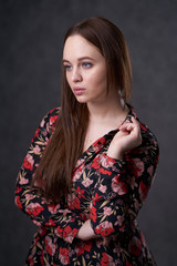 Portrait of a female in a colored dress on gray background