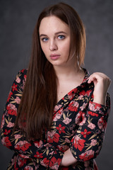 Portrait of a female in a colored dress on gray background