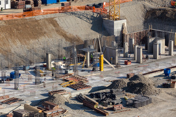 Workers unrecognizable make metal reinforcement for the concrete foundation.