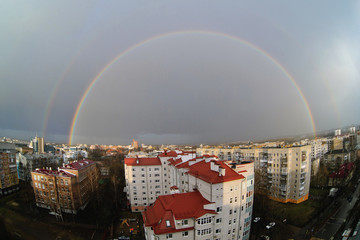 View from the roof on a full rainbow over the city in summer shot on a fisheye lens