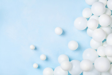 Pastel blue table with white balloons top view. Party or birthday background. Flat lay style.