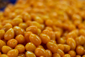 Delicious yellow tomatoes on a market with blurred background.