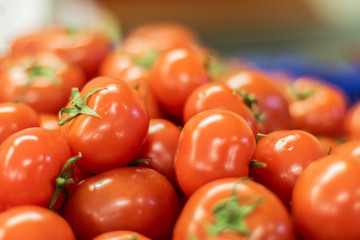 Delicious red tomatoes on a market with blurred background.