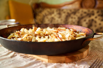 Baked crisp golden deep fried french fries hot potatoes frying and ready to be eaten. Fried potatoes in the old cast-iron pan. Really yummy 
