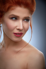 red hair young woman close-up studio beauty portrait on grey background