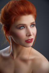 red hair young woman close-up studio beauty portrait on grey background