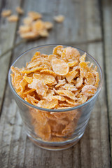 Bowl with cornflakes on grey wooden background. Healthy cereal breakfast for kids.