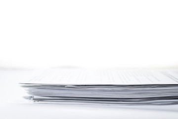 Close-up small stack of papers on white background with copy space, selective focus