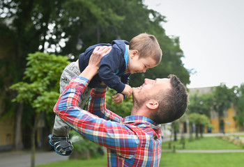 father raise up his son in a park