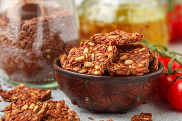 Homemade vegetarian (vegan) cracker flax seed and sunflower with tomato. Healthy gourmet snack. Proper nutrition, diet, superfood. Selective focus