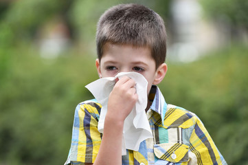 Little boy is blowing his nose