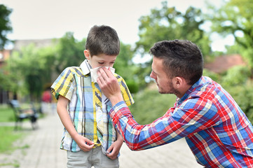 father blowing son's nose