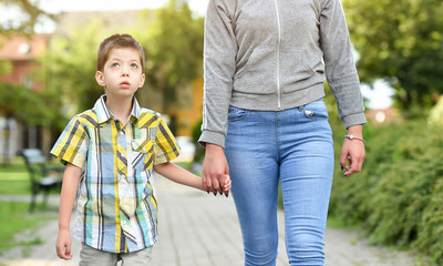 mother and son holding hand in a park