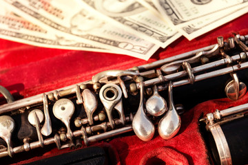 Obraz premium Musical wind instrument oboe in original red case and us dollars. Close-up.