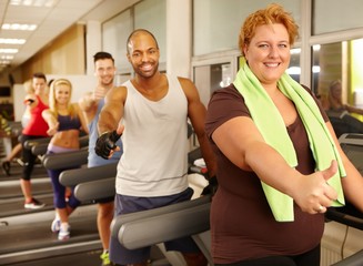 Fototapeta na wymiar Fat woman enjoying training in gym
