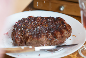 Beef steak cooking. Rib eye steak. Raw meat. Juicy marbled meat on BBQ grill. Medium rare meat roasting