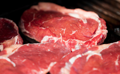 Beef steak cooking. Rib eye steak. Raw meat. Juicy marbled meat on BBQ grill. Medium rare meat roasting
