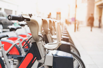 Bicycle rental service on city road parking with sunlight, public transportation concept.