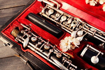 Musical wind instrument oboe in original red case with white flowers. Close-up.