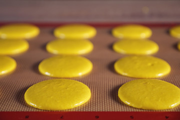 Cooking macaroons on stencil silicone mat on the table, close-up. selective focus