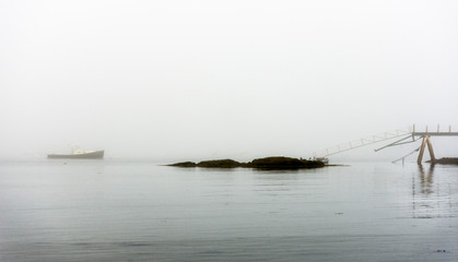 lobster boat in fog anchored with dock