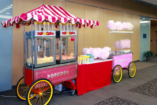 Colored kiosk selling popcorn and cotton candy in the building