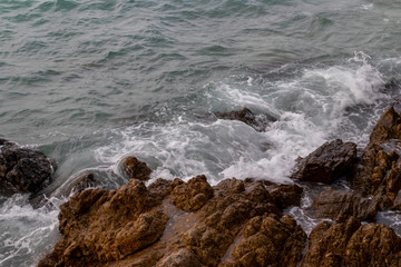 The ocean waves hit the rocks on the rocky beach in the morning, Ocean waves hit the rocks at the beach.