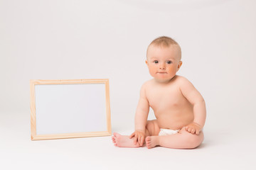 baby boy in diapers on white background, baby 5 months. white board for drawing.